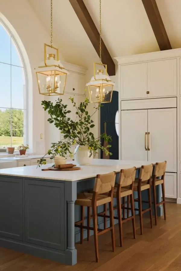 Luxury warm white kitchen with large island, quartz countertops, and timeless pendant lighting.