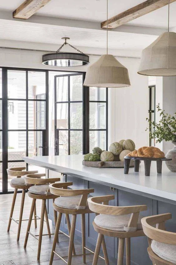 Love this beautiful organic modern kitchen design with woven pendants, wood counter stools and neutral decor - 2024 kitchen cabinet trends - brandon architects