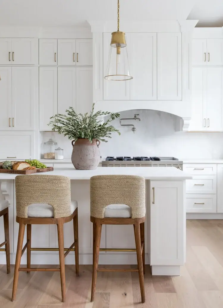 Love this classic kitchen design with white floor-to-ceiling cabinets, glass & brass pendant lights, and seagrass counter stools - kitchen cabinet paint color trends and ideas - salt design